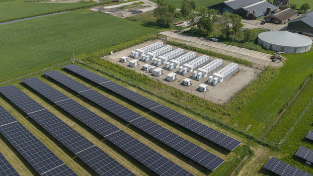 Aerial view of a solar farm with rows of photovoltaic panels and a battery energy storage system next to agricultural fields in Wanneperveen Overijssel Netherlands. Aerial view of a solar farm with rows of photovoltaic panels and a battery energy storage system next to agricultural fields in Wanneperveen Overijssel Netherlands.