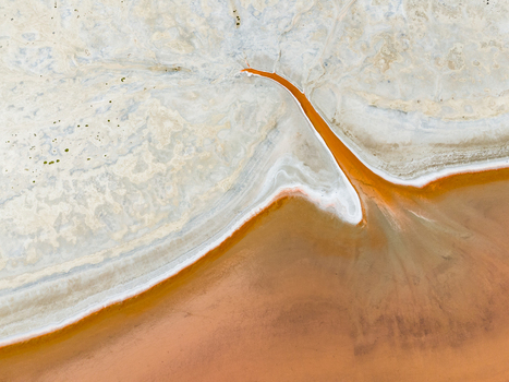Aerial view of an abstract salt lake with vibrant orange water and white salt crusts in the Mallee region Woorinen North Victoria Australia. Aerial view of an abstract salt lake with vibrant orange water and white salt crusts in the Mallee region Woorinen North Victoria Australia.