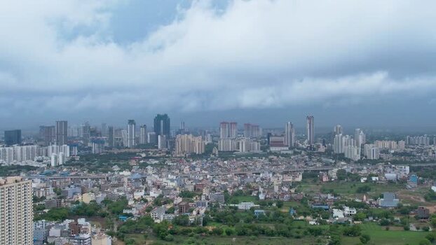 Aerial view of Gurugram skyscrapers and green fields India.