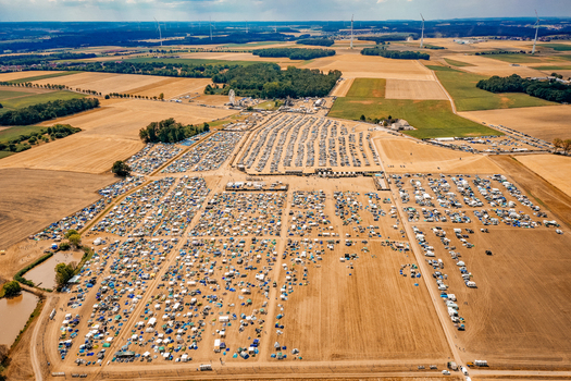 Herzogenaurach Germany 22 July 2022 Aerial view of the Open Beatz Festival campsite with tents and vehicles spread across fields surrounded by forests and wind turbines. Herzogenaurach Germany 22 July 2022 Aerial view of the Open Beatz Festival campsite with tents and vehicles spread across fields surrounded by forests and wind turbines.