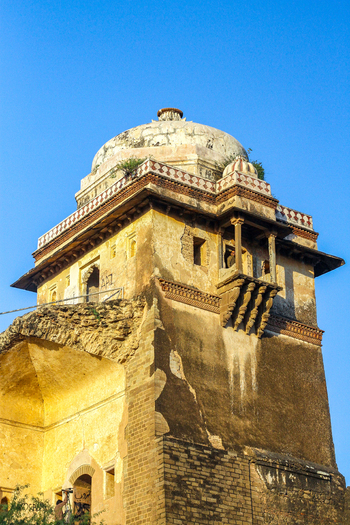 View of the historic Rohtas Fort featuring intricate stone architecture a prominent dome and weathered walls under a clear blue sky in Dina Punjab Pakistan. View of the historic Rohtas Fort featuring intricate stone architecture a prominent dome and weathered walls under a clear blue sky in Dina Punjab Pakistan.