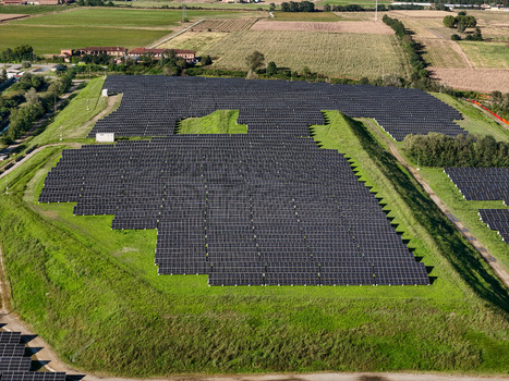 Aerial view of a large solar panel array on a green hillside surrounded by rural farmland in Crescentino Piedmont Italy. Aerial view of a large solar panel array on a green hillside surrounded by rural farmland in Crescentino Piedmont Italy.