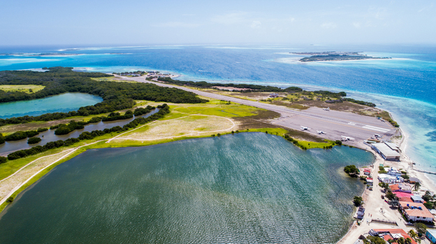 Aerial view of Los Roques archipelago featuring the airport runway lush mangroves and vibrant turquoise waters of the Caribbean Sea in Los Roques Dependencias Federale Venezuela. Aerial view of Los Roques archipelago featuring the airport runway lush mangroves and vibrant turquoise waters of the Caribbean Sea in Los Roques Dependencias Federale Venezuela.