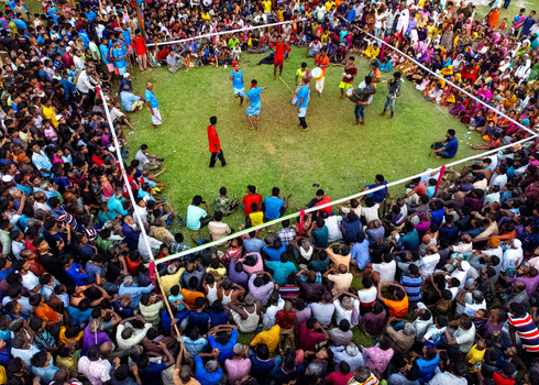 Nilphamari Bangladesh 01 May 2026 Aerial view of a traditional folk performance with performers and drummers in a grassy arena surrounded by a large crowd of spectators. Nilphamari Bangladesh 01 May 2026 Aerial view of a traditional folk performance with performers and drummers in a grassy arena surrounded by a large crowd of spectators.