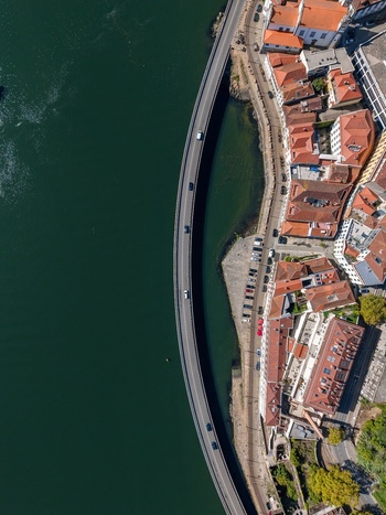 Aerial view of Viaduto do Cais das Pedras along the Douro River with terracotta rooftops and urban waterfront in Porto Porto Portugal.