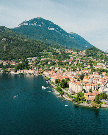 Aerial view of Lake Como and the lakeside town featuring colorful buildings and lush green mountains in the background Menaggio Lombardy Italy.