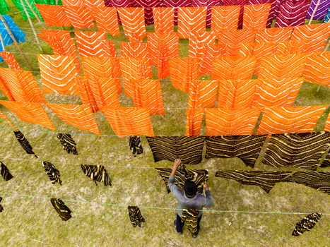 Narayanganj Bangladesh 30 March 2026 Aerial view of vibrant fabrics hanging to dry creating a colorful tapestry against the earth toned ground.