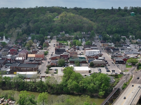 Aerial view of the historic downtown area with brick buildings a white church steeple and lush green hills in Aurora Indiana United States. Aerial view of the historic downtown area with brick buildings a white church steeple and lush green hills in Aurora Indiana United States.
