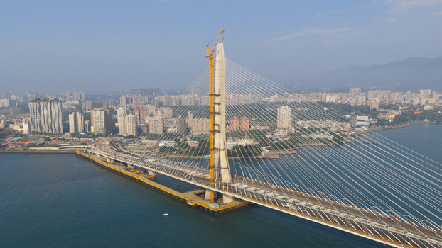 Aerial view of the Danjiang Bridge under construction featuring its pylon and cable stayed design spanning the river with the urban skyline in Tamsui District New Taipei City Taiwan.