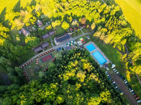 Aerial view of Kemp Zelene udoli with swimming pool small cabins and surrounding forest in Mladejov Kralovehradecky kraj Czechia.