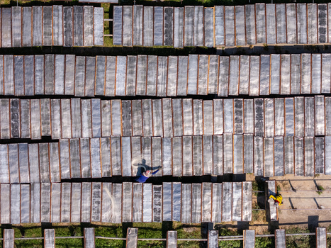 Aerial view of workers drying noodles on racks in a field in Polanharjo Central Java Indonesia.