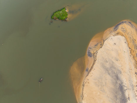 Aerial view of a small green island and sandy banks in calm water with a small boat and people Galle Southern Province Sri Lanka. Aerial view of a small green island and sandy banks in calm water with a small boat and people Galle Southern Province Sri Lanka.