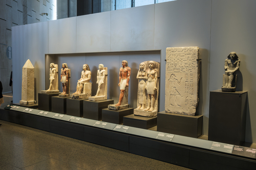 Giza Egypt 16 May 2026 View of ancient Egyptian statues and hieroglyphic stelae on display inside the Grand Egyptian Museum with soft indoor lighting.