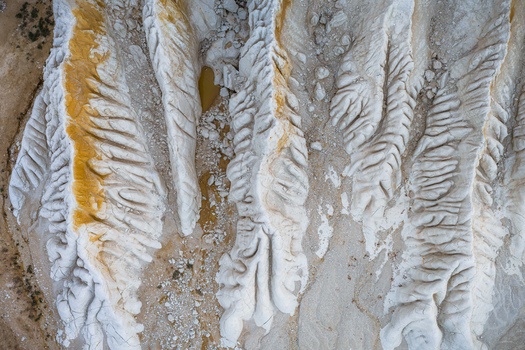 Aerial view of the white chalk ridges and orange mineral deposits of the Tuzbair salt flats in the desert landscape of Mangystau District Mangystau Region Kazakhstan.
