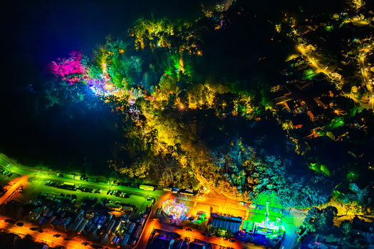Aerial view of the Annafest festival at night with colorful lights illuminating the forest amusement rides and a crowded parking area in Forchheim Bayern Germany. Aerial view of the Annafest festival at night with colorful lights illuminating the forest amusement rides and a crowded parking area in Forchheim Bayern Germany.