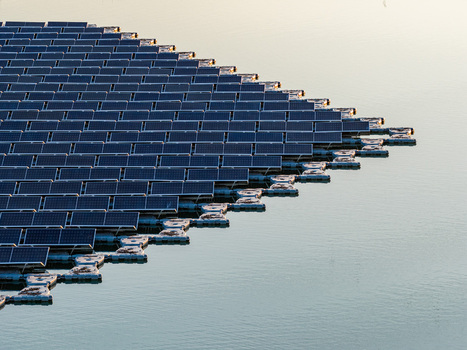 Aerial view of floating photovoltaic system with rows of solar panels on white floats over calm water during golden hour Bensheim Hessen Germany. Aerial view of floating photovoltaic system with rows of solar panels on white floats over calm water during golden hour Bensheim Hessen Germany.