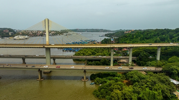 Aerial view of the Atal Setu cable stayed bridge spanning the Mandovi River with traffic and surrounding lush greenery in Panaji Goa India.