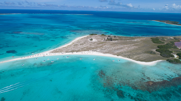 Aerial view of Los Roques archipelago featuring white sand beaches turquoise Caribbean waters coral reefs and small boats in Los Roques Dependencias Federales Venezuela. Aerial view of Los Roques archipelago featuring white sand beaches turquoise Caribbean waters coral reefs and small boats in Los Roques Dependencias Federales Venezuela.