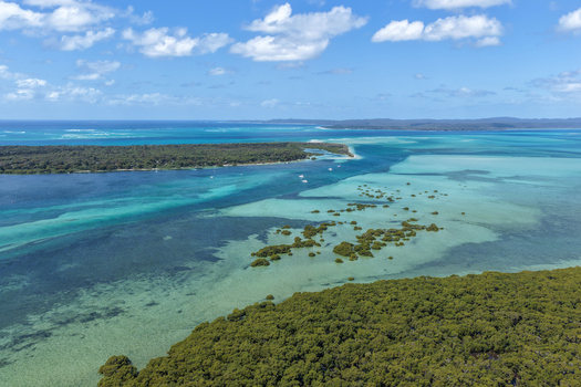 Aerial view of Moreton Island featuring turquoise waters sandbanks and lush mangrove forests under a clear blue sky in Kooringal Queensland Australia. Aerial view of Moreton Island featuring turquoise waters sandbanks and lush mangrove forests under a clear blue sky in Kooringal Queensland Australia.