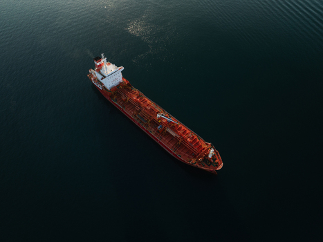 Aerial view of a large red oil tanker ship navigating the calm dark blue waters of the Mediterranean Sea Augusta Sicily Italy. Aerial view of a large red oil tanker ship navigating the calm dark blue waters of the Mediterranean Sea Augusta Sicily Italy.