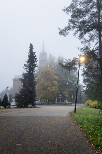 View of the clock tower building surrounded by autumn trees and fog in Jyvaskyla Central Finland Finland.