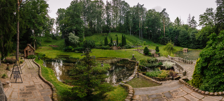 Cesis Latvia 17 July 2025 View of a beautifully landscaped private garden featuring decorative ponds stone pathways sculptures and a recreation terrace nestled in lush greenery.