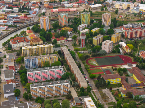 Aerial view of residential apartment blocks a water tower and a sports field with a running track in Breclav South Moravian Region Czechia.