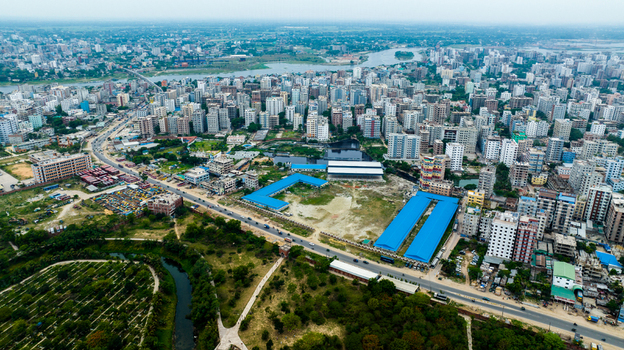 Aerial view of the Rayer Bazaar area featuring dense urban buildings a winding river and green spaces in Dhaka Dhaka Division Bangladesh.