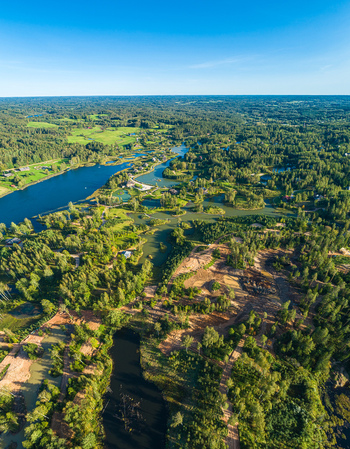 Aerial view of a lush landscape with winding lakes dense forests and patches of cleared land in Latvia. Aerial view of a lush landscape with winding lakes dense forests and patches of cleared land in Latvia.