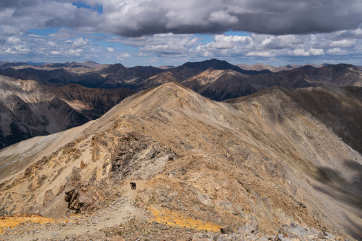 View of the rocky ridge of Mount Missouri in the Collegiate Peaks Wilderness with a hiking trail and dramatic clouds under morning light in Buena Vista Colorado United States.
