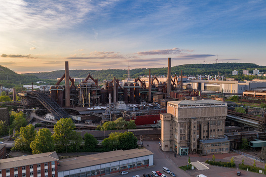 Volklingen Germany 09 May 2026 Aerial view of the Volklingen Ironworks with its industrial blast furnaces rusty pipes and tall chimneys under a soft sunset sky. Volklingen Germany 09 May 2026 Aerial view of the Volklingen Ironworks with its industrial blast furnaces rusty pipes and tall chimneys under a soft sunset sky.