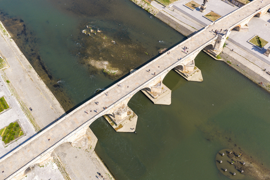 Aerial view of the historic Stone Bridge spanning the Vardar River with pedestrians walking across its stone arches in Skopje Greater Skopje North Macedonia. Aerial view of the historic Stone Bridge spanning the Vardar River with pedestrians walking across its stone arches in Skopje Greater Skopje North Macedonia.