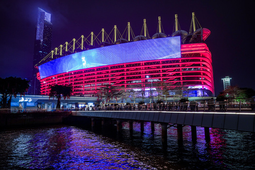 Guangzhou Guangdong Province China 24 February 2024 View of Haixinsha Asian Games Park stadium illuminated in red at night with a large digital screen overlooking the river. Guangzhou Guangdong Province China 24 February 2024 View of Haixinsha Asian Games Park stadium illuminated in red at night with a large digital screen overlooking the river.