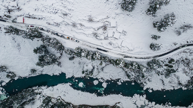 Aerial view of the turquoise river snaking through a snow laden valley alongside a road lined with vehicles near Sharda Azad Kashmir Pakistan. Aerial view of the turquoise river snaking through a snow laden valley alongside a road lined with vehicles near Sharda Azad Kashmir Pakistan.