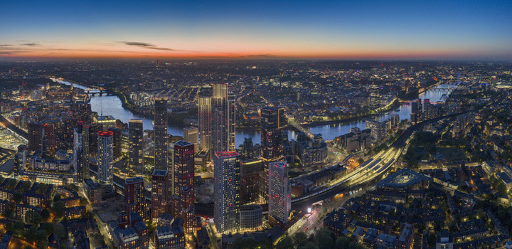 Aerial view of the modern Vauxhall skyline and the River Thames winding through the city under a sunset sky at dusk London England United Kingdom.
