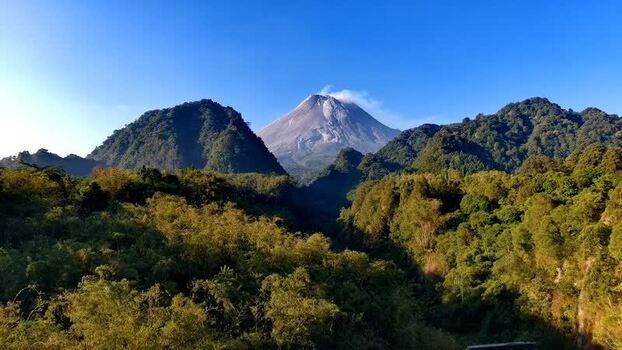 Aerial view of Mount Merapi volcano above lush forests Indonesia.