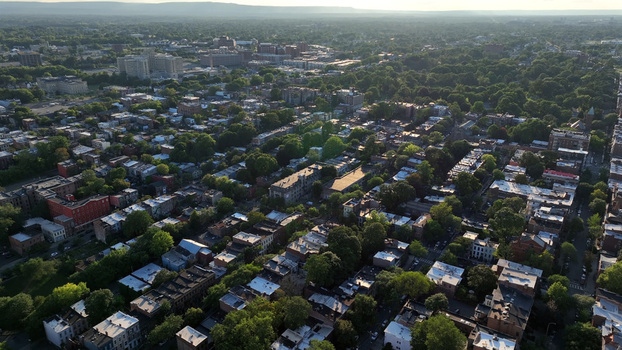 Aerial view of the historic city of Albany with dense residential neighborhoods lush green trees and urban architecture under soft sunlight in Albany New York United States.