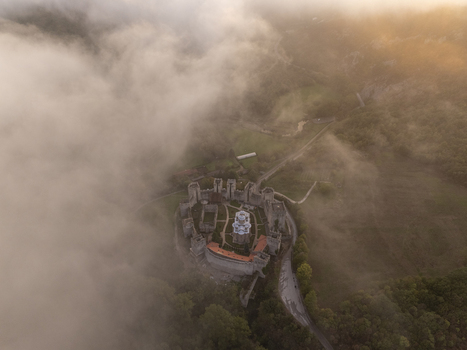 Aerial view of Manasija Monastery surrounded by thick morning fog and lush forest in Despotovac Pomoravski okrug Serbia.