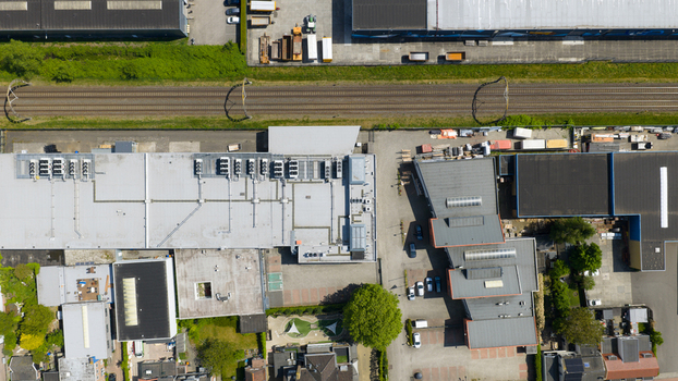 Aerial view of industrial warehouses and office buildings with flat roofs HVAC units and adjacent railway tracks in Nieuwegein Utrecht Netherlands. Aerial view of industrial warehouses and office buildings with flat roofs HVAC units and adjacent railway tracks in Nieuwegein Utrecht Netherlands.