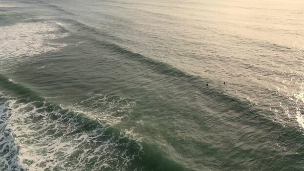 Aerial view of Praia da Mata with surfers riding waves in Portugal. Aerial view of Praia da Mata with surfers riding waves in Portugal.