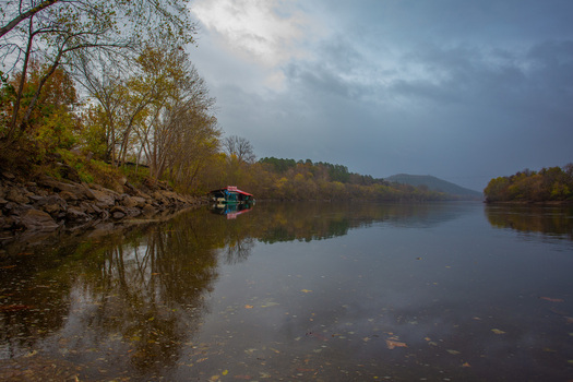 View of still waters reflecting the muted autumn foliage and an anchored houseboat under a brooding sky Little Rock Arkansas United States. View of still waters reflecting the muted autumn foliage and an anchored houseboat under a brooding sky Little Rock Arkansas United States.