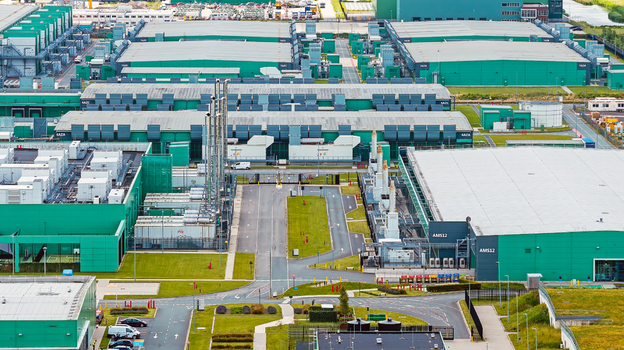 Aerial view of a large data center facility with green industrial buildings cooling units and paved access roads in Middenmeer North Holland Netherlands.