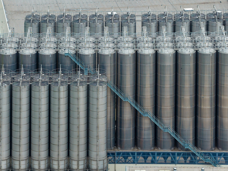 Aerial view of industrial storage facilities for petrochemical products featuring rows of tall metal silos and metal staircases in Kutno Lodz Voivodeship Poland. Aerial view of industrial storage facilities for petrochemical products featuring rows of tall metal silos and metal staircases in Kutno Lodz Voivodeship Poland.