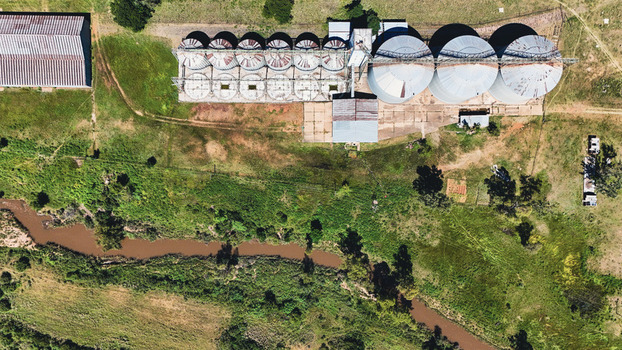 Aerial view of large grain silos and agricultural buildings near a winding river in Alma Waterberg District Municipality Limpopo South Africa. Aerial view of large grain silos and agricultural buildings near a winding river in Alma Waterberg District Municipality Limpopo South Africa.