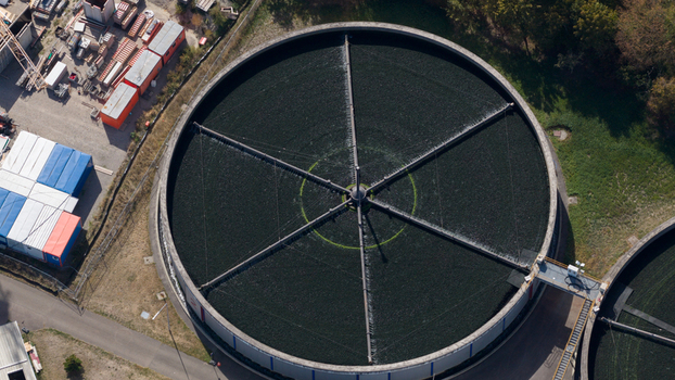 Aerial view of the circular sedimentation tank at the Klarwerk Karlsruhe water treatment plant with rotating machinery and industrial infrastructure in Karlsruhe Baden Wurttemberg Germany.
