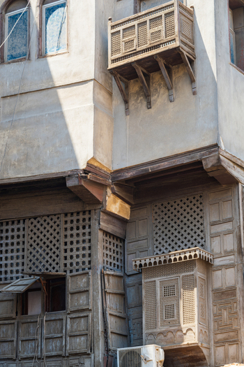 View of traditional mashrabiya wooden lattice windows and an ornate balcony on the historic Al Ghuri Dome complex building facade Cairo Egypt. View of traditional mashrabiya wooden lattice windows and an ornate balcony on the historic Al Ghuri Dome complex building facade Cairo Egypt.