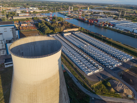 Aerial view of the Cargovil battery energy storage system with rows of battery containers and a large cooling tower in an industrial landscape in Vilvoorde Vlaanderen Belgium. Aerial view of the Cargovil battery energy storage system with rows of battery containers and a large cooling tower in an industrial landscape in Vilvoorde Vlaanderen Belgium.