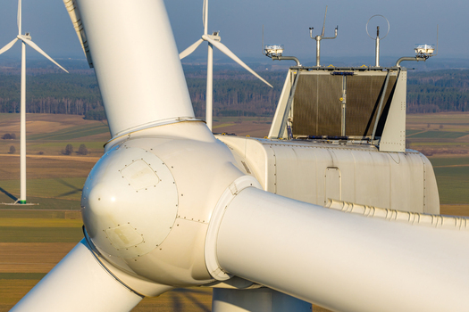 Aerial view of a wind turbine nacelle and blades with meteorological sensors set against a rural landscape in Poland. Aerial view of a wind turbine nacelle and blades with meteorological sensors set against a rural landscape in Poland.