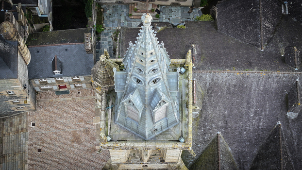 Aerial view of the Gothic spire of Eglise Saint Melaine de Morlaix surrounded by historic stone rooftops and a cobblestone courtyard in Morlaix Bretagne France. Aerial view of the Gothic spire of Eglise Saint Melaine de Morlaix surrounded by historic stone rooftops and a cobblestone courtyard in Morlaix Bretagne France.