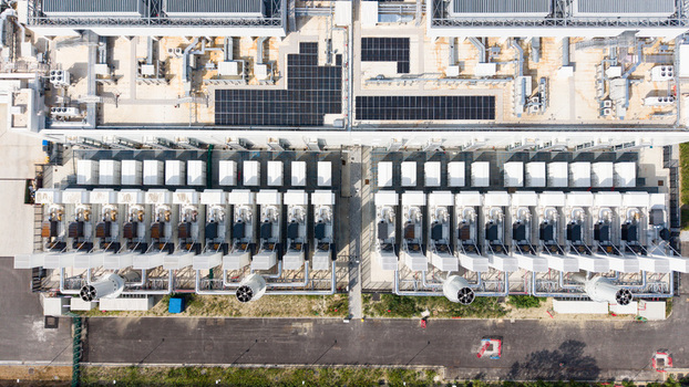 Aerial view of a modern data center campus with rows of cooling units industrial infrastructure and solar panels on the roof in Melegnano Lombardy Italy.